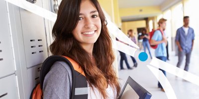 Student holding books in hallway of school
