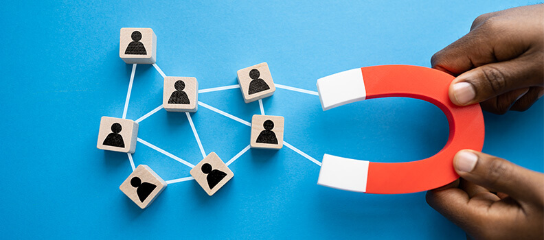 Man holding magnet attracting leading